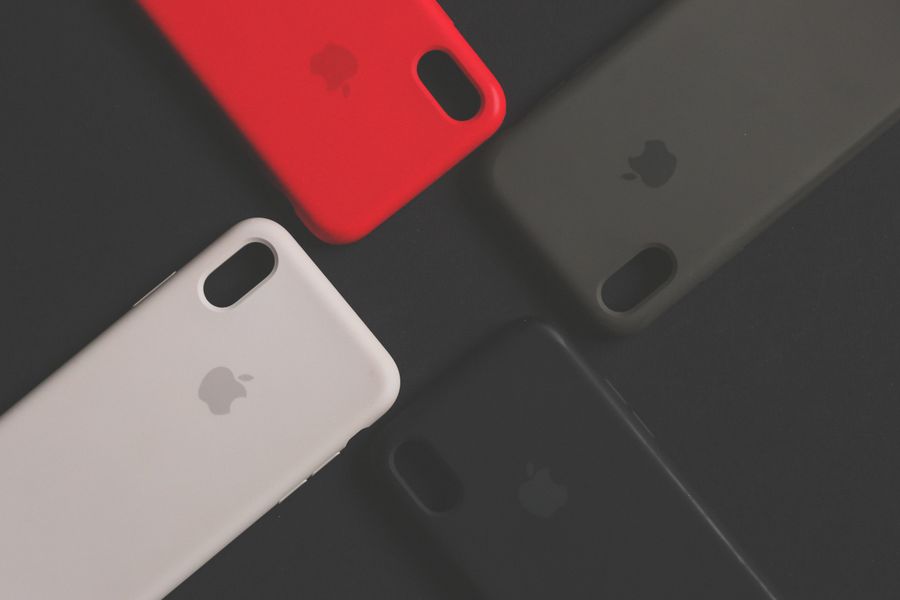Collection of girly aesthetic phone covers in different colors arranged on a dark surface